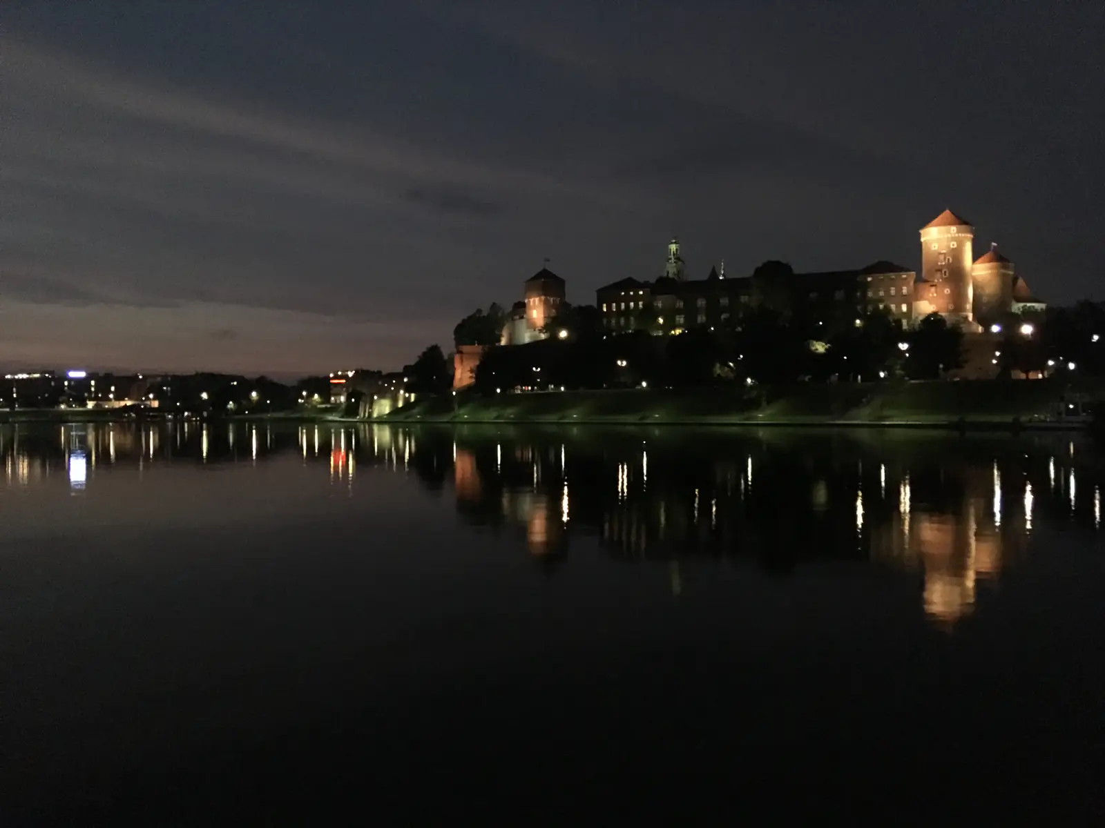 Nocna panorama Krakowa z Wawelem i Wisłą w lipcu — zdjęcie ilustracyjne nocnego życia miasta