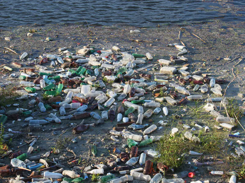 Plastikowe śmieci i odpady dryfujące po powierzchni rzeki — zdjęcie ilustracyjne łapaczy śmieci na rzece