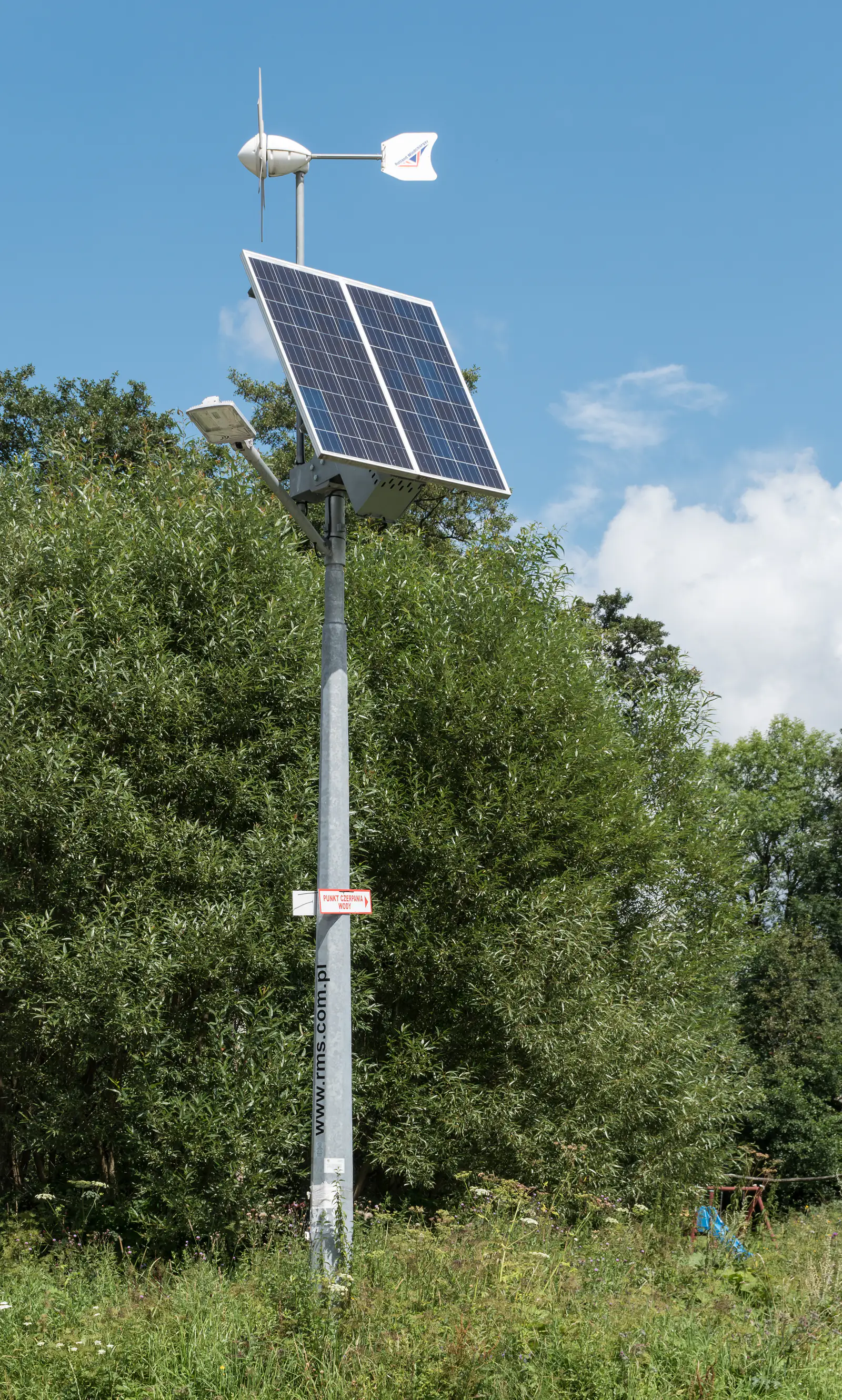 Solarna latarnia uliczna z panelem fotowoltaicznym na wiejskiej drodze w Polsce — zdjęcie ilustracyjne oświetlenia ulicznego w sołectwach
